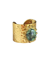 Goldener Ring mit grün gesprenkeltem Stein und Sonnenmotiv in Schalenform